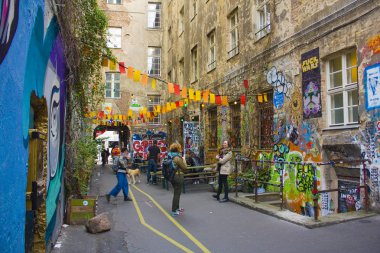 Berlin, Almanya - 25 Eylül 2018: Haus Schwarzenberg - Street sanat sokak dar geçit yanında bir kafe ile duvar resimleri, Etiketler ve paste-ups ile patlayan bir avlu yol açar