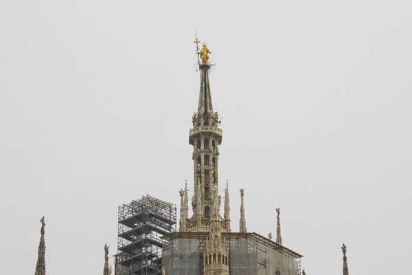ITALY, MILAN - November 1, 2018: Gilded statue of Madonna on the Duomo di Milano