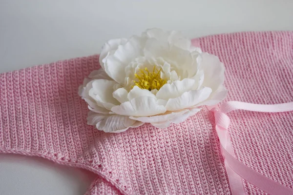 Fragment of fashion crochet female pink handbag with a white flower close up