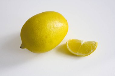 Olgun sarı limon ve beyaz arka plan üzerinde izole dilim