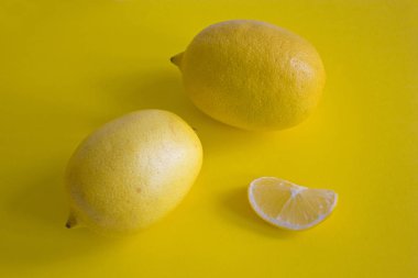 Olgun sarı limon dilimi üzerinde sarı arka plan izole
