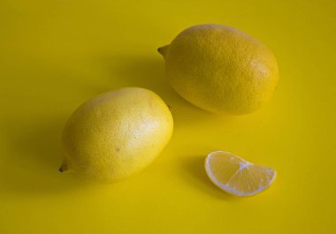 Olgun sarı limon dilimi üzerinde sarı arka plan izole