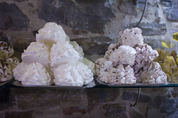 White tasty meringues in italian shop