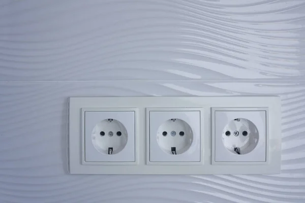 Electricity point on white textured wall