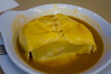 Francesinha (--dan ekmek, peynir, domuz eti, jambon, sosis, domates soslu sandviç) - Porto, Portekiz üzerinden geleneksel yemekler 