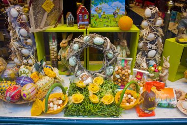 Belçika, Brüksel - 1 Mayıs 2019: Brüksel'de bir şekerleme vitrininde geleneksel renkli Paskalya çikolatası yumurtaları ve tavşanlar