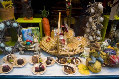 Belçika, Brüksel - 1 Mayıs 2019: Brüksel'de bir şekerleme vitrininde geleneksel renkli Paskalya çikolatası yumurtaları ve tavşanlar