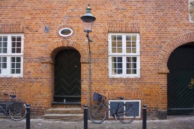  Parked bicycles near brick wall of building of Copenhagen, Denmark clipart