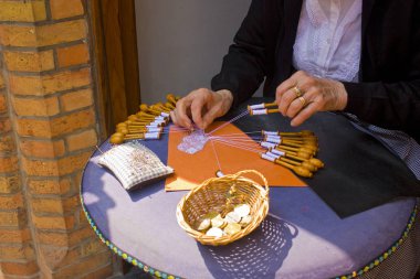 Hands of an elderly lady weaving lace in Bruges clipart