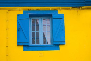 Sarı duvardaki mavi pencere