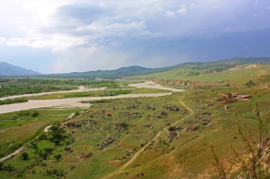Gürcistan'da Cave Town Uplistsikhe bir nehir ve dağlar ile güzel manzara