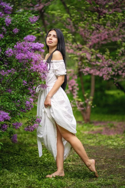 Piękna kobieta ciesząc się zapachem Lilac. — Zdjęcie stockowe