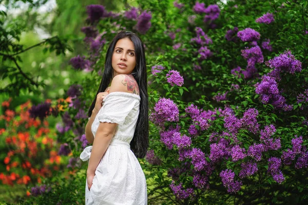 Piękna kobieta korzystających liliowy ogród, młoda kobieta z kwiatami w zielonym parku. — Zdjęcie stockowe