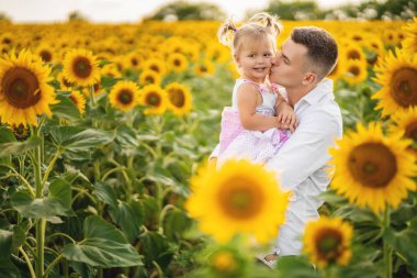 Baba ve kızı ayçiçeği tarlasında eğleniyor