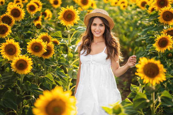 Beautiful girl in hat in a sunflower field. 4th of July. Fourth of July. Freedom.