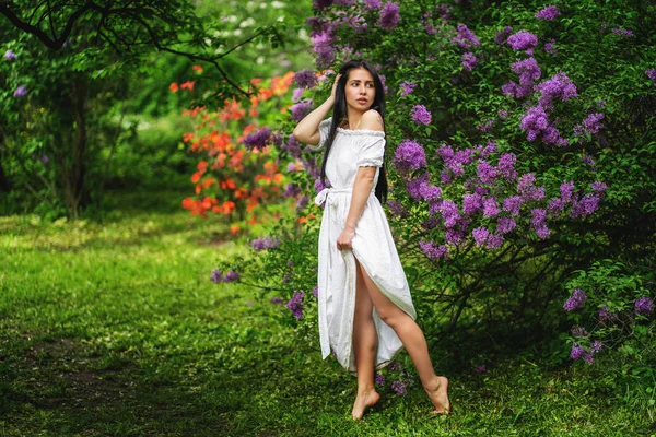春のライラックの花を持つ女の子。女性らしさ、優しさの概念。明るい紫色の花の女の子. — ストック写真