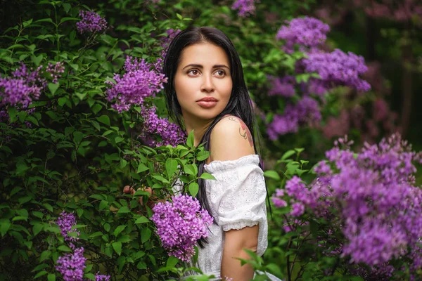 Portrait of authentic girl in blooming bush with purple flowers — Stock Photo, Image