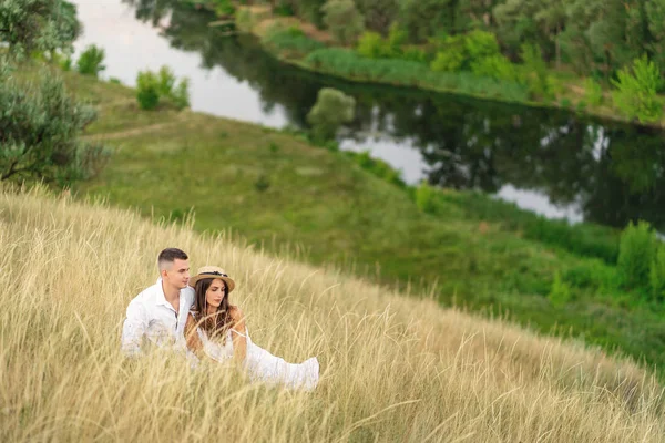 Couple romantique profiter de l'autre au coucher du soleil. Ils sont assis à la — Photo