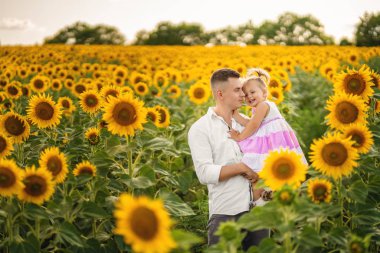 Ayçiçeği arasında yürüyüşte küçük kızı olan baba