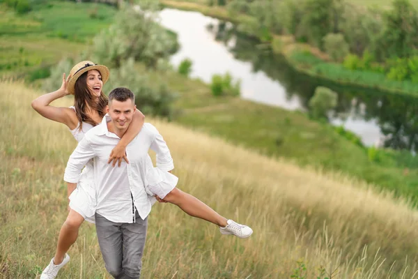 Portrait of young man giving piggyback ride to pretty woman. Hap — Stock Photo, Image