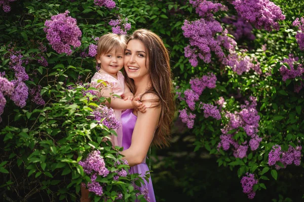 La madre e suo figlio si godono la primavera presto. Albero lilla in fiore — Foto Stock