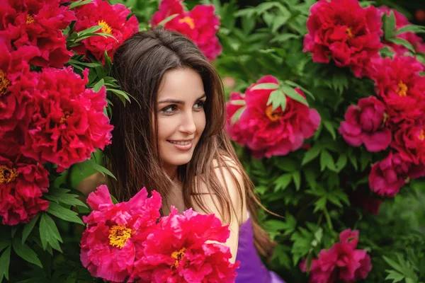 Zbliżenie zdjęcie pięknej młodej kobiety otoczonej kwiatami — Zdjęcie stockowe