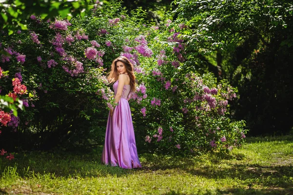 Szczęśliwa młoda kobieta korzystających zapach w kwitnący ogród wiosna — Zdjęcie stockowe
