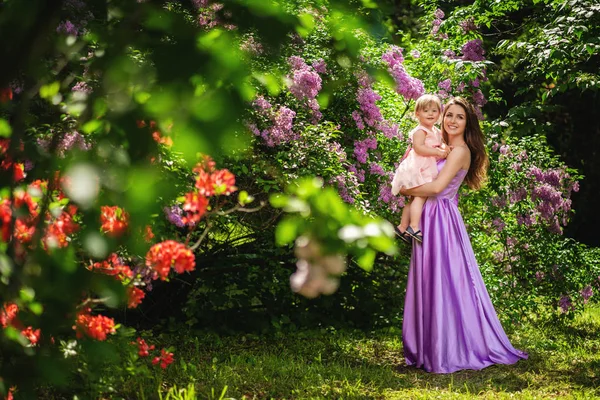 Felice madre di famiglia e sua figlia che giocano al parco. Fioritura — Foto Stock