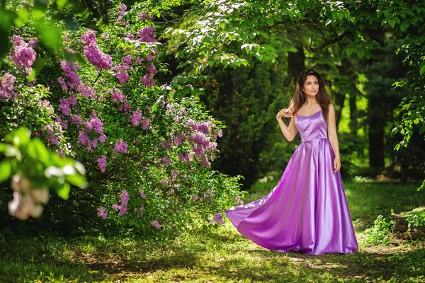 Jolie femme posant près de l'arbre en fleurs. Parc de printemps — Photo