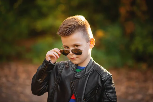 Autentyczny chłopiec w okularach przeciwsłonecznych patrzący w kamerę. moda trendy ki — Zdjęcie stockowe