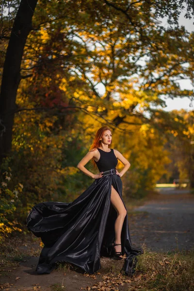 Modelo bonito vestindo vestido maxi e posando na floresta de outono . — Fotografia de Stock