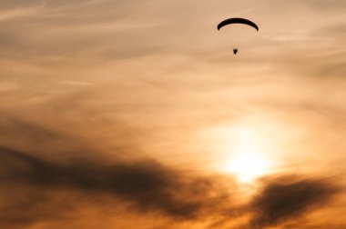 Gün batımında uçan bir Paramotor 'un küçük silueti