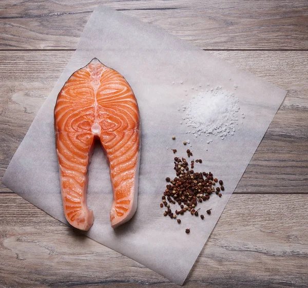 Salmon steak with salt and pepper on baking paper Stock Photo