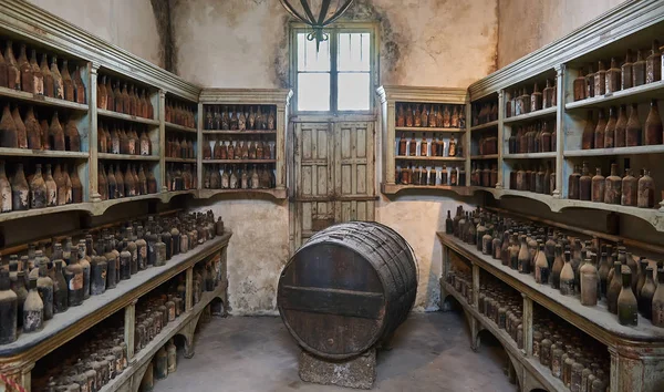 stock image Room with aged bottles and barrel with wine