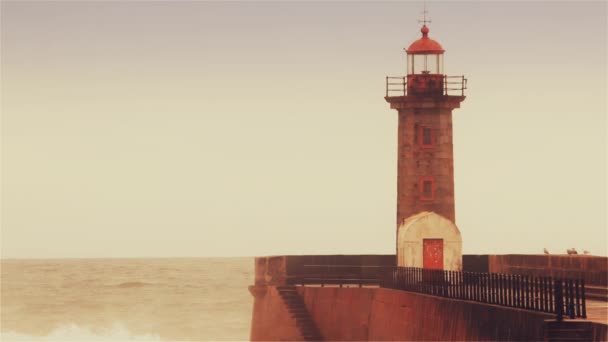 Silné vlny přestávka o molo, maják na pobřeží Atlantského oceánu — Stock video