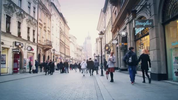 Cracovia, Polonia - 18 de enero: Los turistas pasean por la hermosa calle del casco antiguo. Un par de jóvenes se están besando. Chica solitaria — Vídeos de Stock