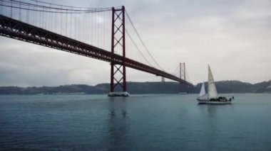 Güzel bir yat Köprüsü yakınlarında Tagus Nehri üzerinde 25 Nisan Lizbon'da yelken