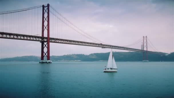 Sebuah kapal pesiar bagus berlayar di sungai Tagus dekat jembatan pada tanggal 25 April di Lisbon — Stok Video