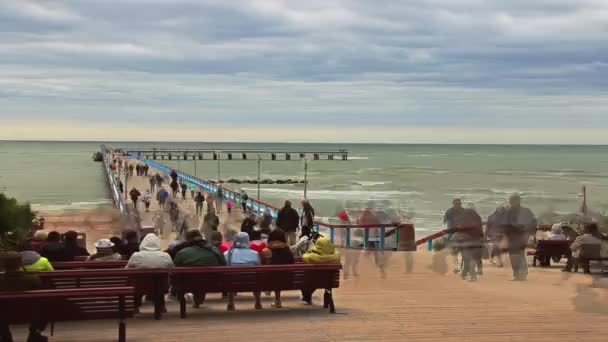 Palanga a tenger, a híd. Emberek séta a hídon át a tenger. A Balti-tenger homokos partja. TimeLapse, frame-by-frame lövés — Stock videók