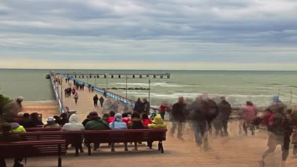 Palanga a tenger, a híd. Emberek séta a hídon át a tenger. A Balti-tenger homokos partja. TimeLapse, frame-by-frame lövés — Stock videók