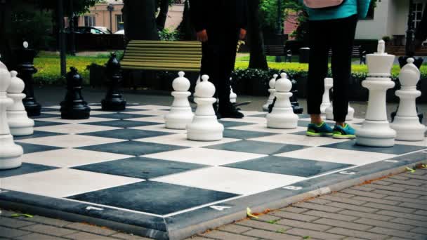 Les adolescents jouent aux échecs en plein air dans une grande rue — Video