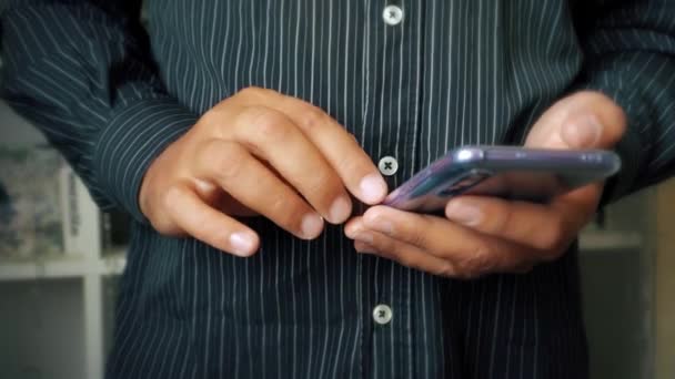 Téléphone portable moderne dans les mains d'un homme gros plan. — Video