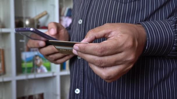 Чоловік здійснює оплату кредитною карткою та мобільним телефоном — стокове відео
