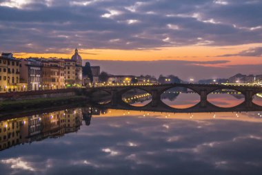 Ortaçağ köprünün Carriya Arno Nehri, günbatımı manzara üzerinde. Görünüm üzerinden sahil Floransa'da Arno Nehri'nin.