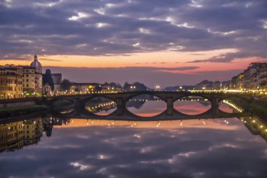 Ortaçağ köprünün Carriya Arno Nehri, günbatımı manzara üzerinde. Görünüm üzerinden sahil Floransa'da Arno Nehri'nin.