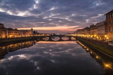 Ortaçağ köprünün Carriya Arno Nehri, günbatımı manzara üzerinde. Görünüm üzerinden sahil Floransa'da Arno Nehri'nin.