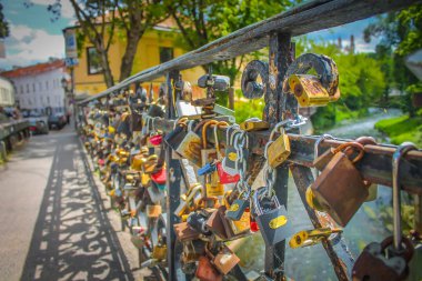 Metal çit köprünün üzerinde parlak ve romantik aşk kilitleri.