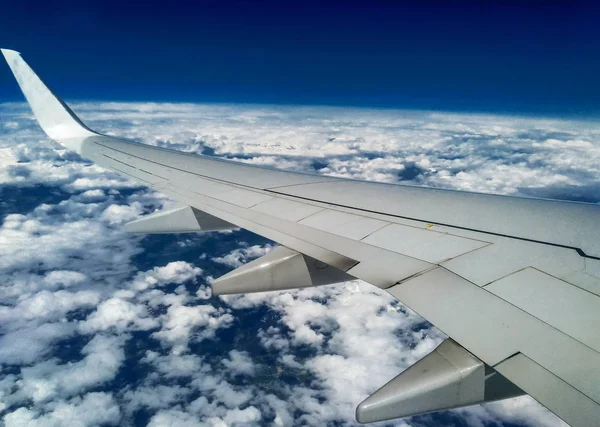 Montagne e neve bianca sulle cime sotto l'ala dell'aereo durante il volo — Foto Stock