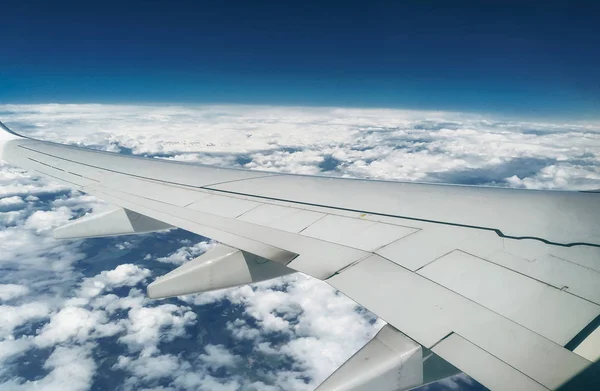 Montagne e neve bianca sulle cime sotto l'ala dell'aereo durante il volo — Foto Stock