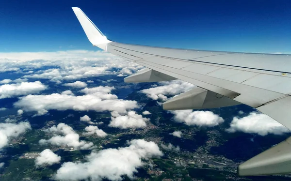 Bergen en witte sneeuw op de toppen onder de vleugel van het vliegtuig tijdens de vlucht — Stockfoto